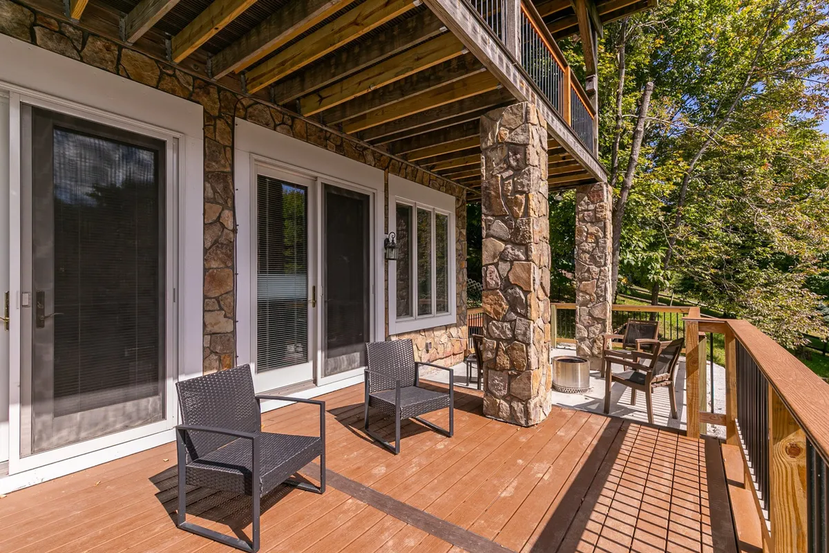 A close-up of the home’s outdoor area featuring stone pillars, comfortable seating, and a wooden railing overlooking a scenic view. The setting is perfect for relaxing, enjoying nature, or intimate evenings under the stars.